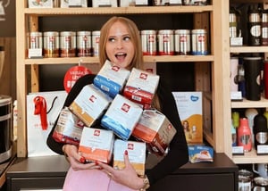 Woman holding coffee in the Aš Myliu Kavą store