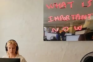 female customer service agent sitting at her laptop wearing a headset